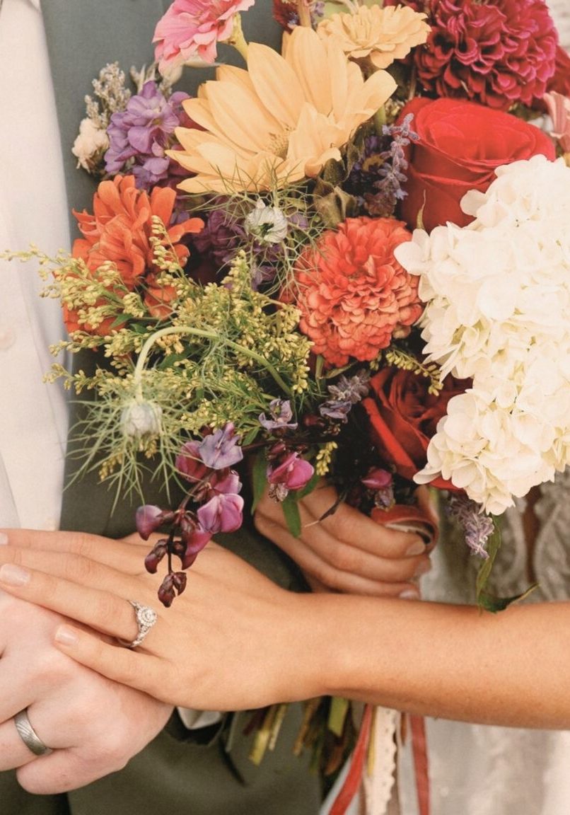 Close-up of bride’s hands showing seamless spray tan blend while holding bridal bouquet - Sunny Daze Sunless