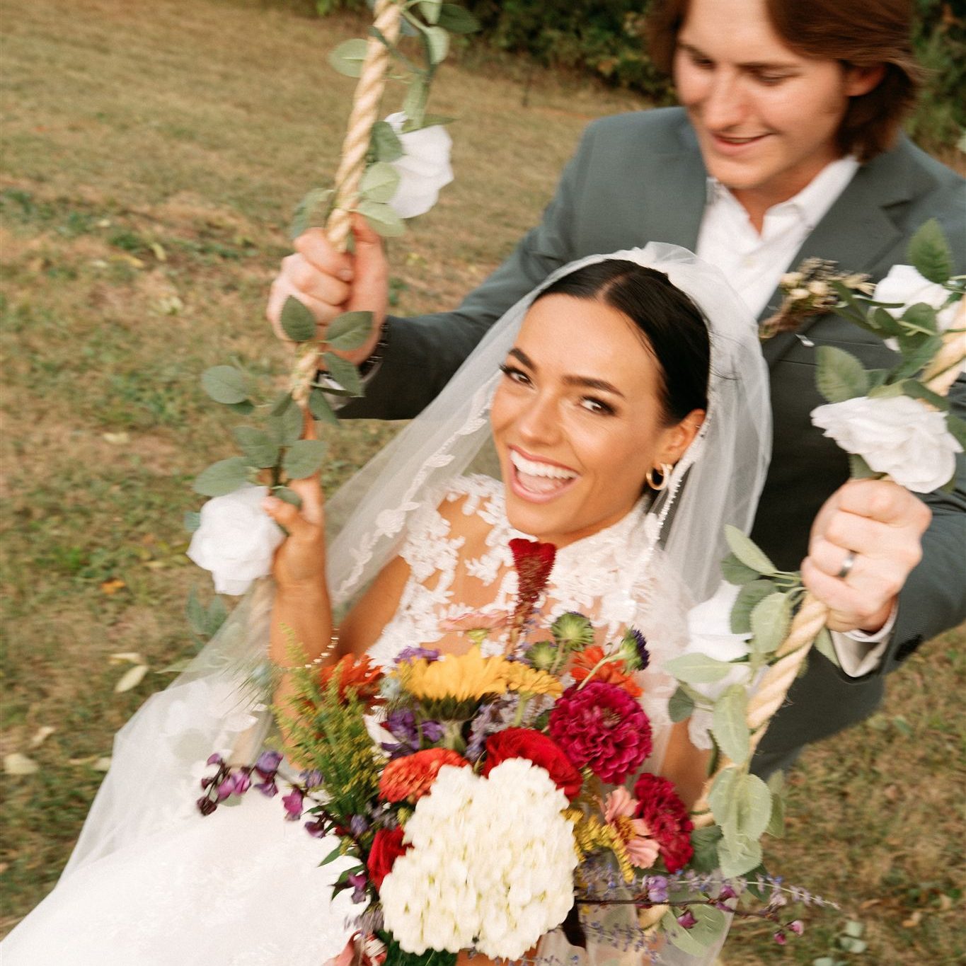 Glowing bride on swing with groom showing natural spray tan by Sunny Daze Sunless in Kansas